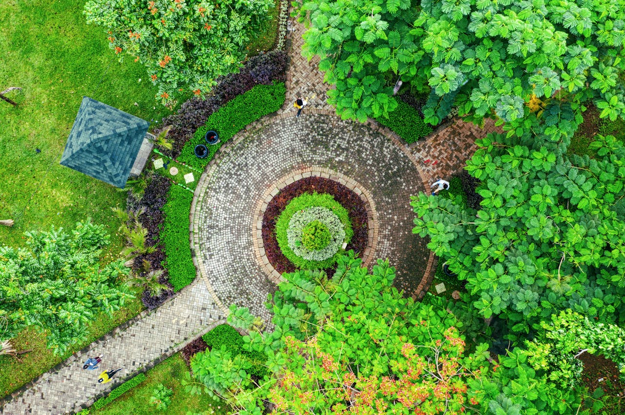 Circular pathway surrounded by dense foliage in a Jakarta park, aerial perspective.